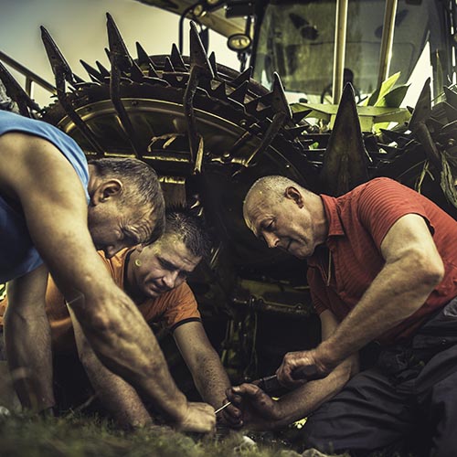 Farmers fixing a tractor