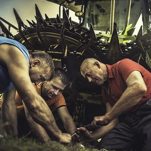 Farmers fixing a tractor